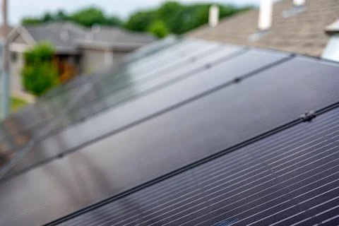Selective focus on solar panels installed on a residential asphalt shingle roof Foto stock