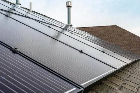 Selective focus on solar panels installed on a residential asphalt shingle roof Foto stock