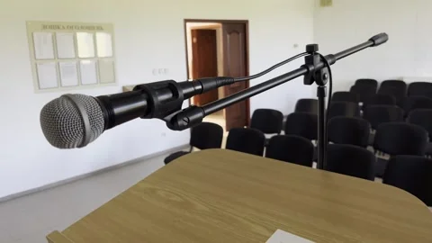 Selective focus on solitary microphone on stage awaiting presenter Stock Footage 313713185