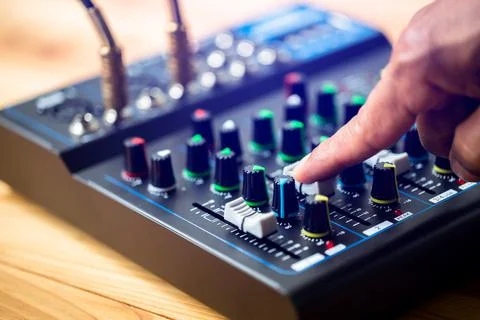 Selective focus to sound electronics mixer and equalizer with hand to turning Stock Photos