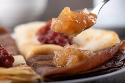 Selective focus. Spoon with apple jam over pancakes. Stock Photos