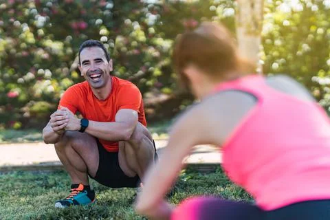 Selective focus on a squatting man exercising outdoors Stock Photos