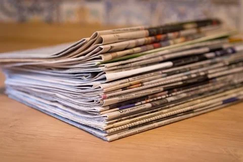 Selective focus of the stacking newspapers folded place on wooden table Stock Photos