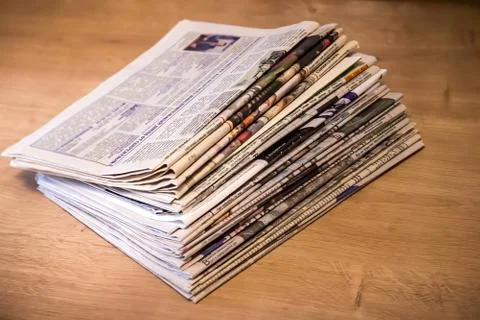 Selective focus of the stacking newspapers folded place on wooden table Stock Photos