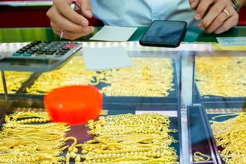Selective focus to staff hand will writing sale order of gold jewelry in the  Stock Photos