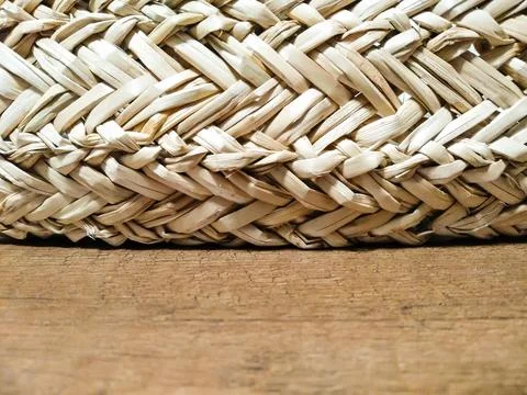 Selective focus straw decor lies on wooden table. The texture of straw pots. Foto stock