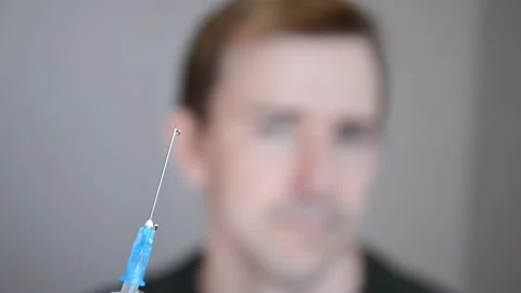 Selective focus on syringe with liquid on blurred background of man. Stock Footage 164666972