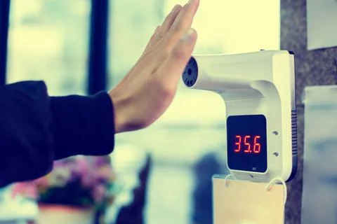 Selective focus to temperature scanning machine at hand for fever. Foto stock