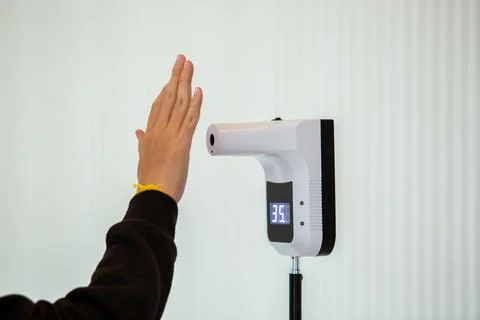 Selective focus to temperature scanning machine at hand for fever before ente Stock Photos