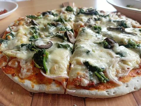 Selective focus of a thin crust Pizza with cheese and olive in a restauran Stock Photos