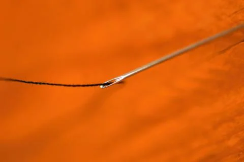 Selective focus, Threading a needle with sewing thread, sewing concept Stock Photos