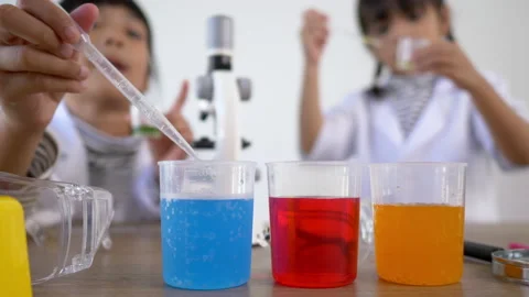 Selective focus at three colors liquids in beakers, blur Asian little girl 스톡 동영상 172190896