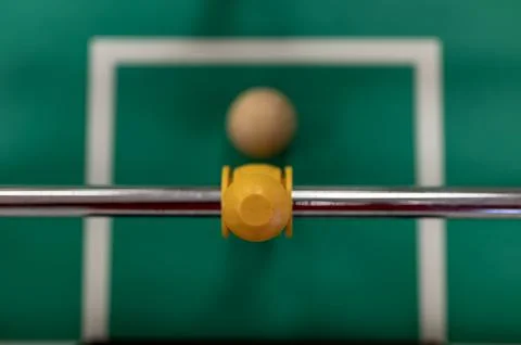 Selective focus top view on a foosball goalie blocking the ball insider the box. Stock Photos