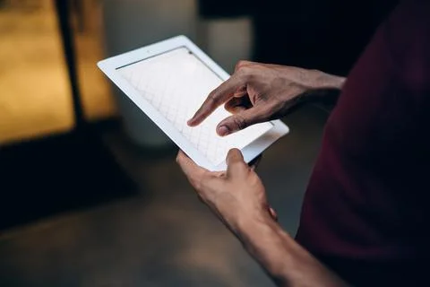 Selective focus on touchscreen of modern digital tablet in hands of male blogger Stock Photos