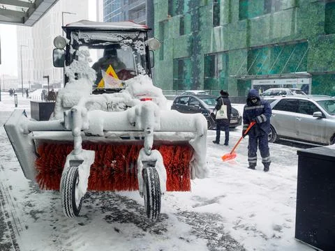 Selective focus on a tractor with a snow brush. Stock Photos
