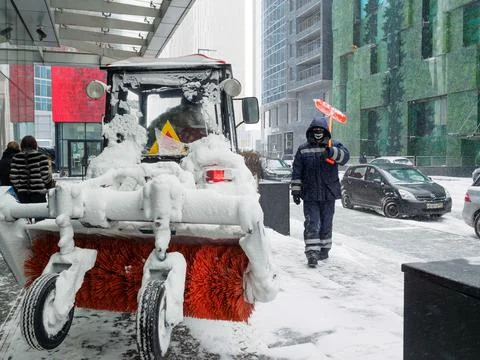 Selective focus on a tractor with a snow brush. Stock Photos