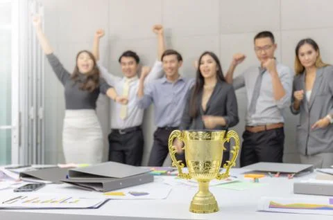 Selective focus of trophy with blurred success group of business people team Фото