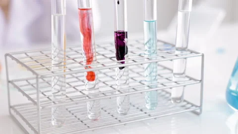 Selective focus tube and cute elementary girl with lab coat learning chemis.. Video stock 243426499