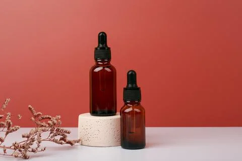 Selective focus, two dark transparent glass bottles with skin serum or oil for Stock Photos