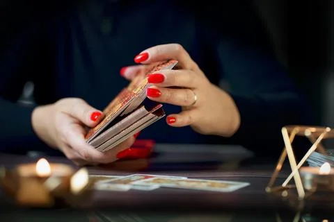 Selective Focus of two hands shuffling and adjusting tarot cards Stock Photos