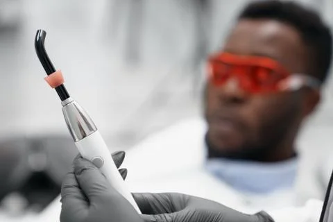 Selective focus of ultraviolet device in hands of dentist Stock Photos