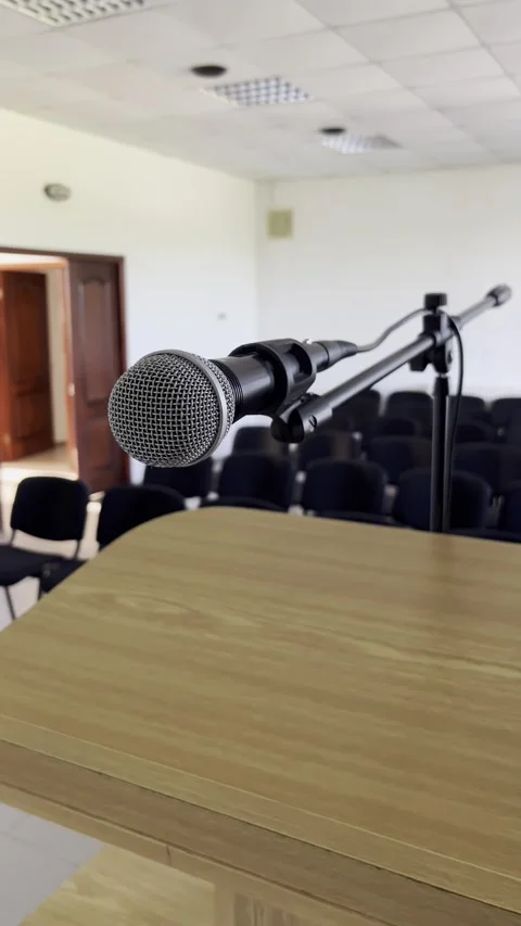 Selective focus on vacant venue spotlighting single microphone at podium Stock Footage 313713577
