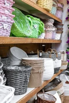 Selective focus of various wicker flower pots and colorful baskets on a shelf in Stock Photos