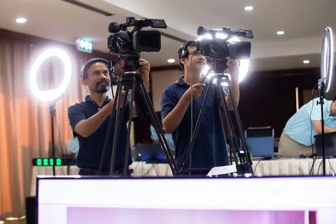 Selective focus to VDO camera with blurry cameraman working with  blurry ri.. Stock Photos