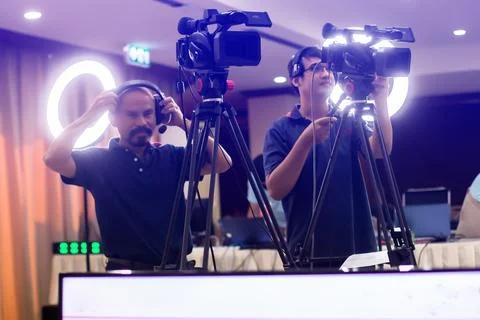 Selective focus to VDO camera with blurry cameraman working with  blurry ri.. Stock Photos