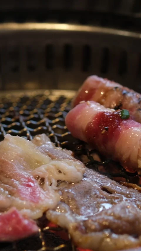 Selective focus view to the mushroom wrapped with bacon meat while being grilled Stock Footage 316069744