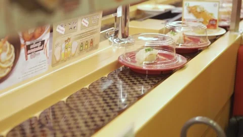 Selective focus view to Sushi belt conveyer while pickup a plate of sushi a.. Video stock 341843597