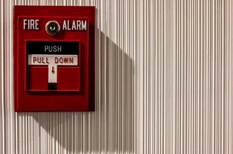 Selective focus on a wall mounted fire alarm switch in a empty hallway Stock Photos
