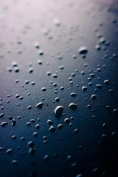 Selective focus on water drops on slippy surface of black synthetic fabric .. Foto stock