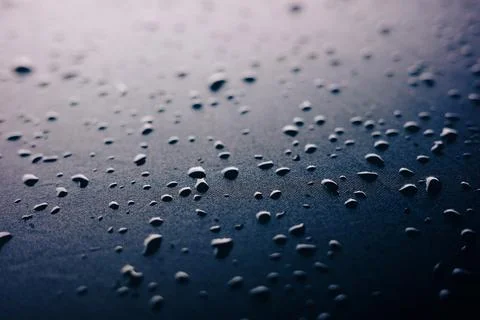 Selective focus on water drops on slippy surface of black synthetic fabric .. Stock Photos