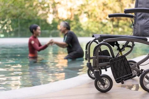Selective focus off wheelchair background of physical therapist helping sen.. Stock Photos