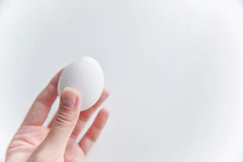 Selective focus at the white egg in the hand Stock Photos