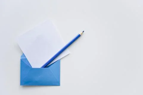 Selective focus, white paper sheet and blue pencil out of the blue envelope Stock Photos
