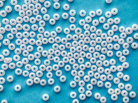 Selective focus, white pearl beads for needlework on a blue background. Making Stock Photos