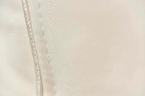 Selective focus at the white stitch on the beige fabric Foto stock