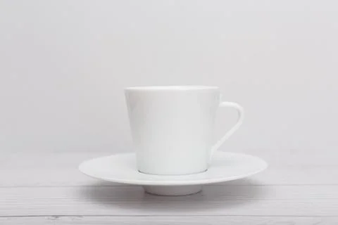 Selective focus, white tea or coffee cup on wooden table against white blurry Stock Photos