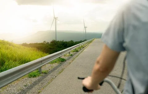 Selective focus on wind farm with rearview of person riding a bicycle as fo.. 库存照片