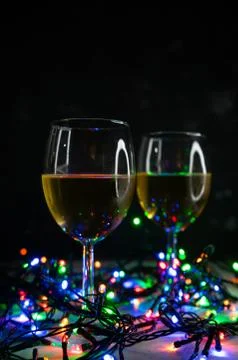 Selective focus. Wine glasses in the light of Christmas lights Foto stock