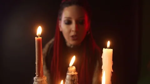 Selective focus of witch telling spell and blows out candles 스톡 동영상 125024278
