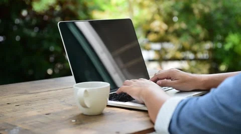 Selective focus at woman hand using computer with white coffee cup put beside in 库存影片 68989814