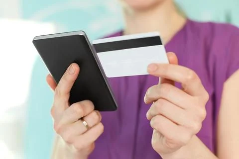 Selective focus on woman`s hands hold modern black cell phone and plastic c.. Stock Photos
