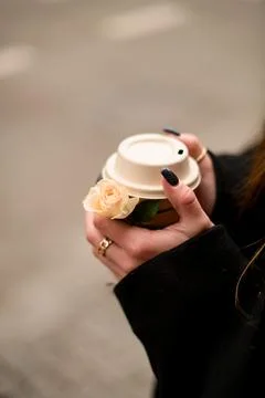 Selective focus of woman's hands vith dark manicure holding paper cup of coffe Stock Photos