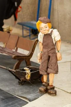 Selective focus of a wooden puppet with string clothes on the street Foto stock