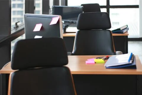 Selective focus at wooden table desk in office business room with big windows Stock Photos