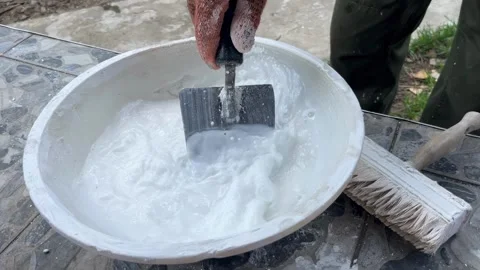 Selective focus worker mixing lime for wall coating Stockbeeldmateriaal 334329555