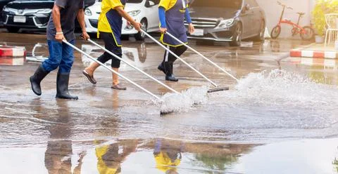 Selective focus to worker using wiper or squeegee to clean floor surface. Stock Photos